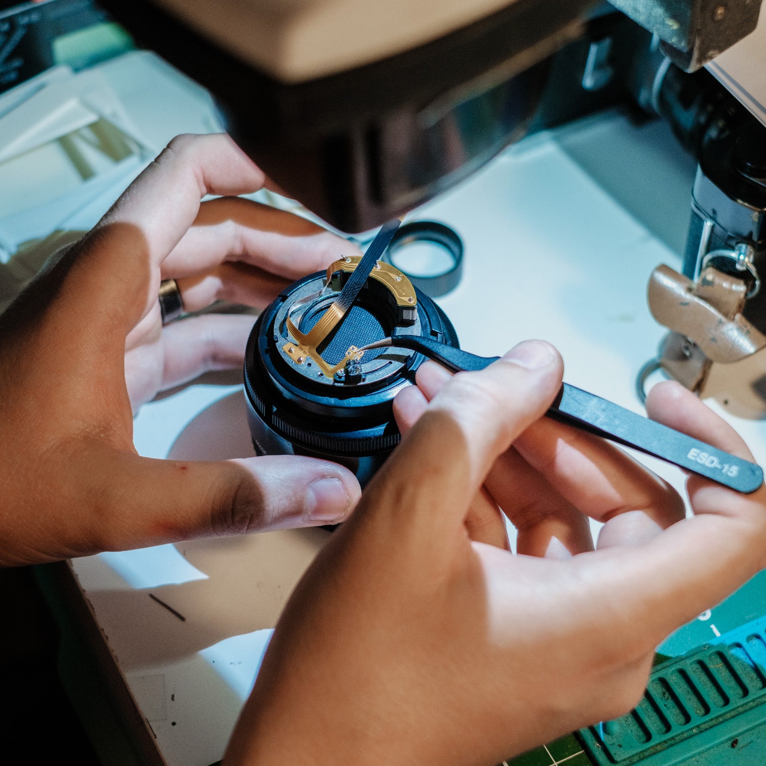 Film camera lens repair tech working on film camera lens fix