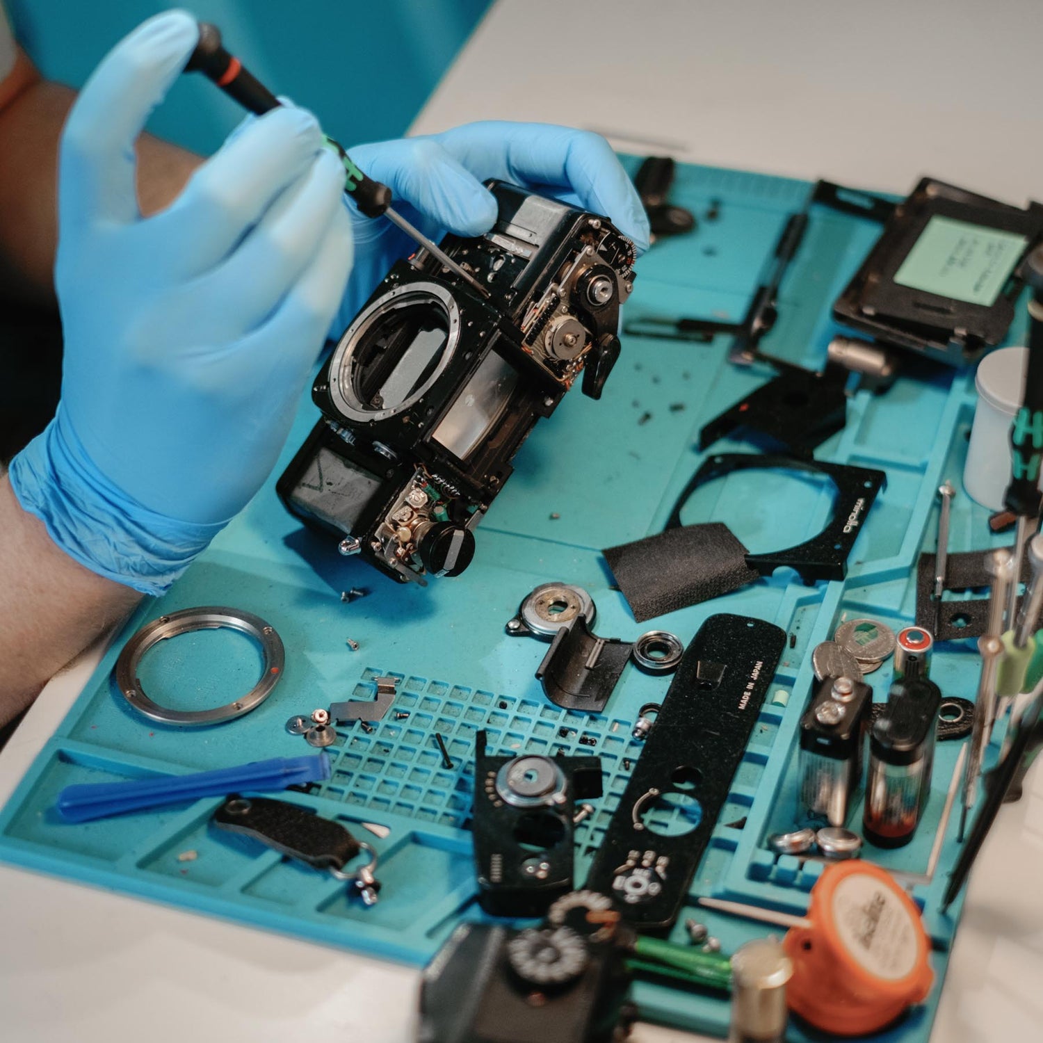 Coastal tech fixing a film camera with film camera repair set up