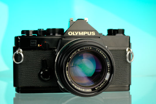 Olympus OM-1 35mm SLR Film Camera (Black) + 50mm f/1.4 Black Nose Lens